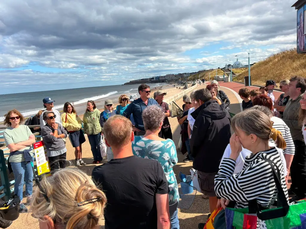 Volunteers gathered on the promenade for a beach cleanup briefing