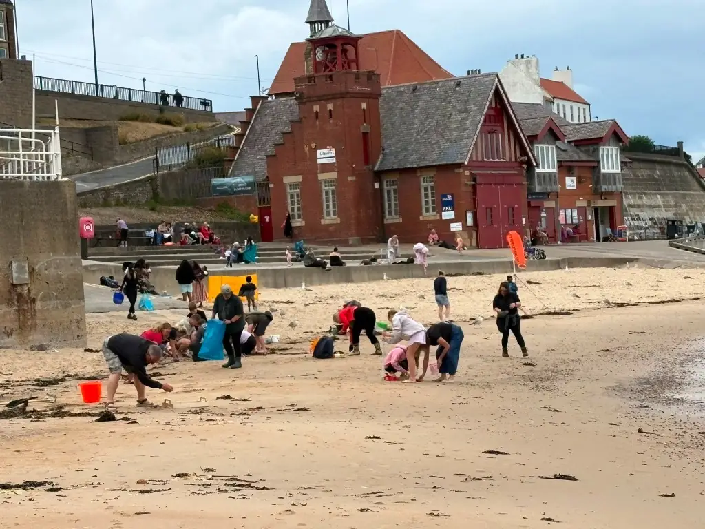 Volunteers cleaning the beach in front of the RNLI lifeboat station